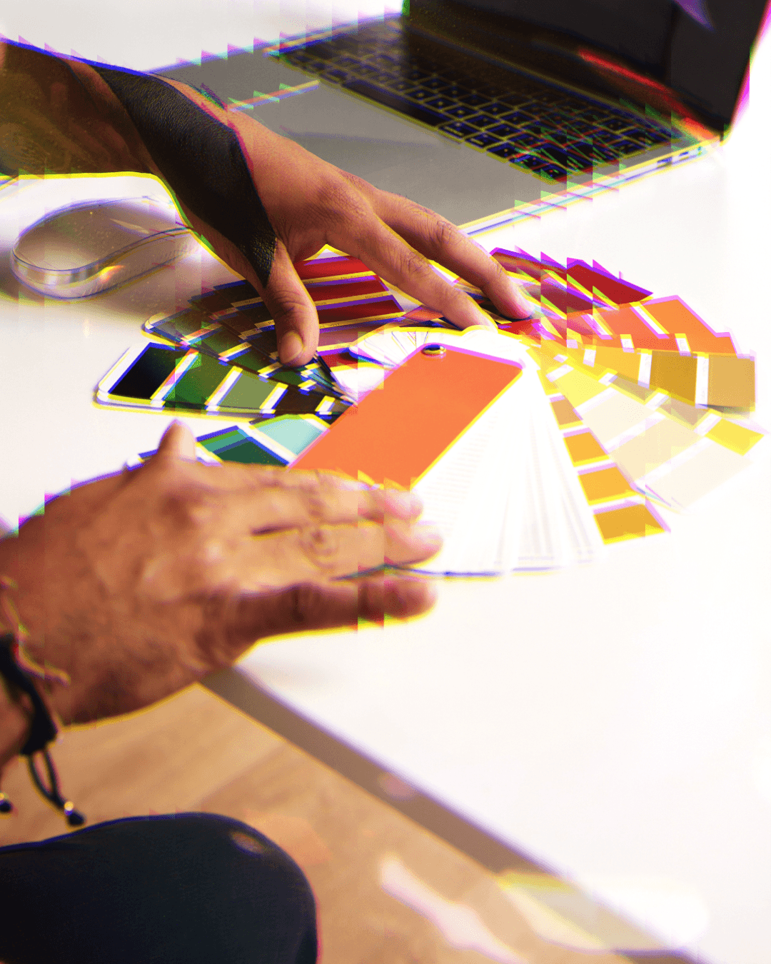 Pessoa mexendo em várias paletas de cores, simbolizando branding, com filtro de prisma